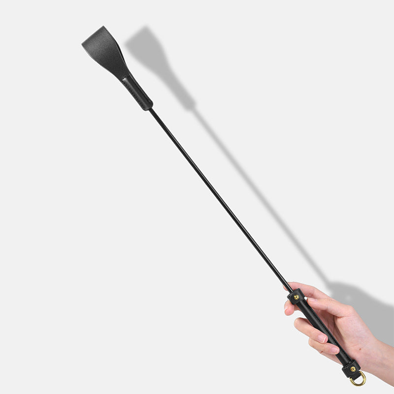 angled view of black and gold leather riding crop