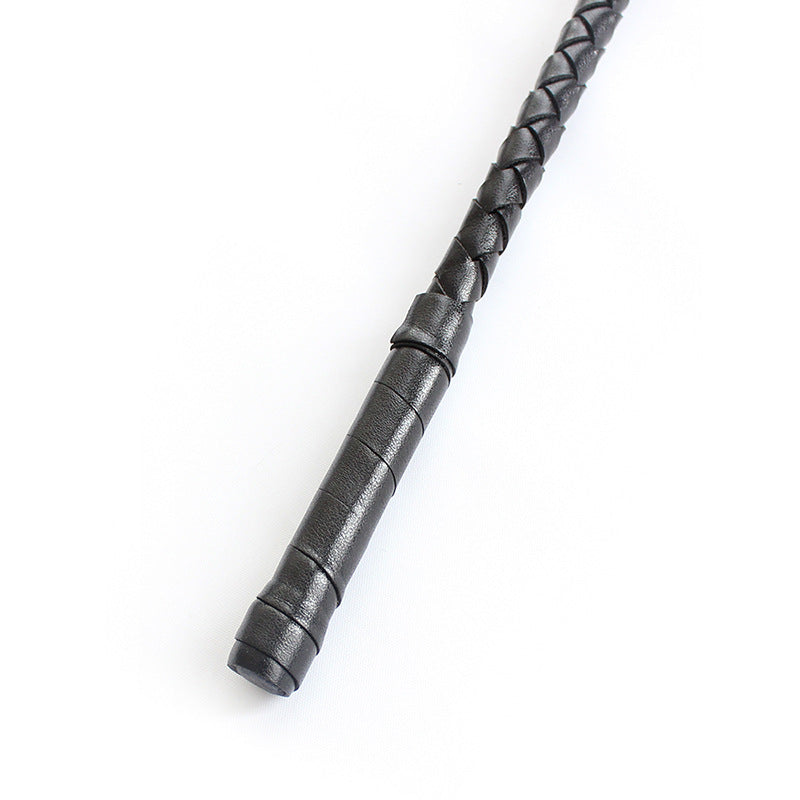 Close-up of black lace ribbon decoration on riding crop handle