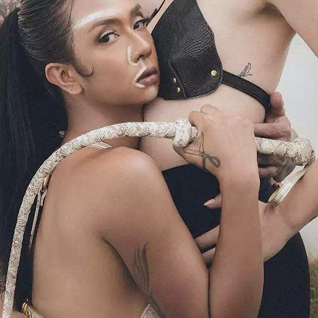 atmospheric presentation of python embossed leather whip emphasizing authority and craftsmanship