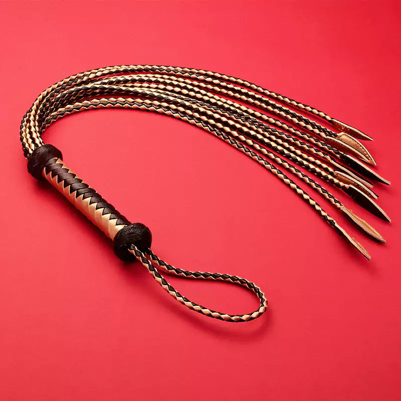performance-style presentation of black and gold willow-leaf leather flogger