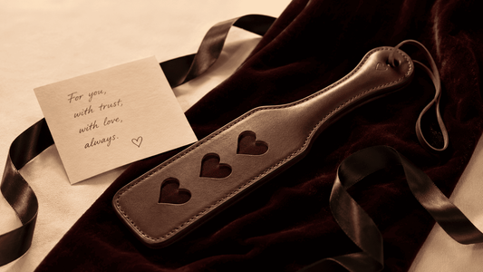 carefully chosen leather paddle beside handwritten card on dark velvet gift presentation