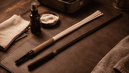 multi-rod and black cane with cleaning cloths and care spray on a warm leather surface