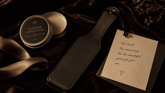 curated impact play gift selection on dark surface leather paddle and accessories