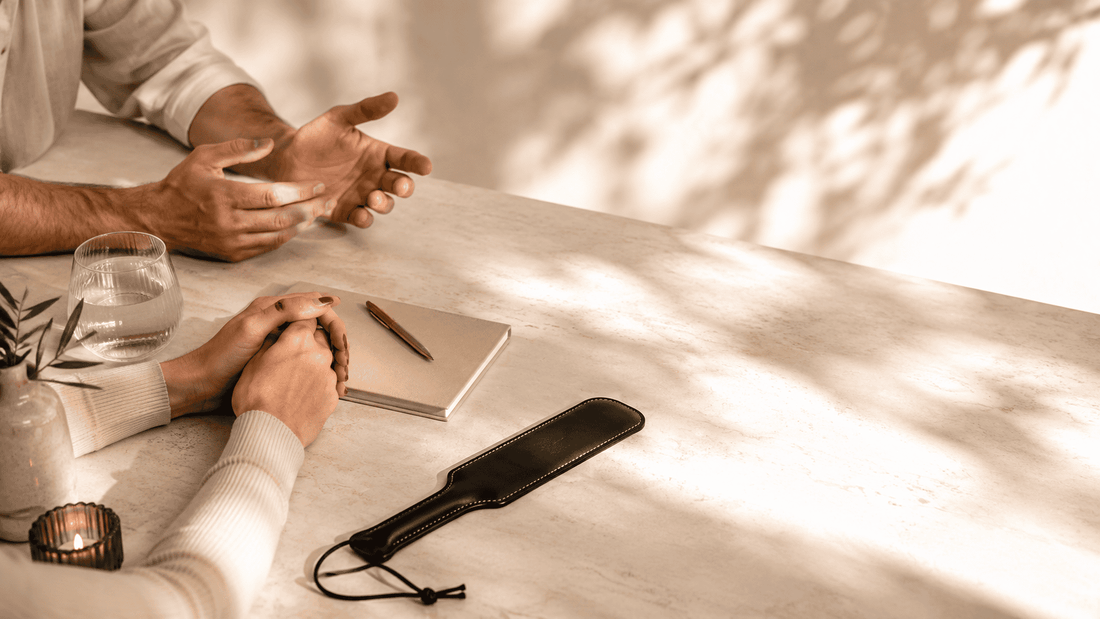 two partners seated close together with leather paddle and journal showing relationship reflection