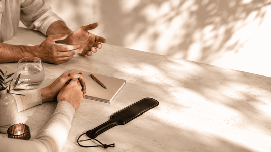 two partners seated close together with leather paddle and journal showing relationship reflection