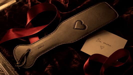 leather paddle with dark red ribbon and card on velvet valentines gift presentation