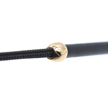 Close-up of shaft connection and gold hardware on black cowhide riding crop