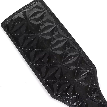 Close-up of black diamond-embossed faux leather paddle surface