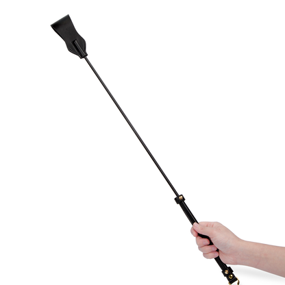 Black fiberglass riding crop handheld demonstrating wrist alignment