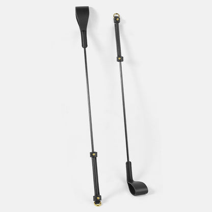 two black and gold leather riding crops displayed together