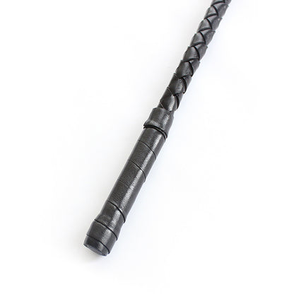 Close-up of black lace ribbon decoration on riding crop handle