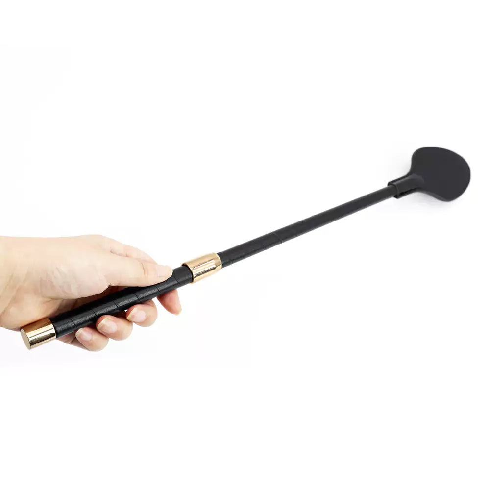 Long version black leather riding crop paddle held in hand