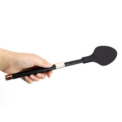 Short version black leather riding crop paddle held in hand