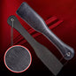 Close-up of vertical and horizontal grain texture on leather spanking paddle