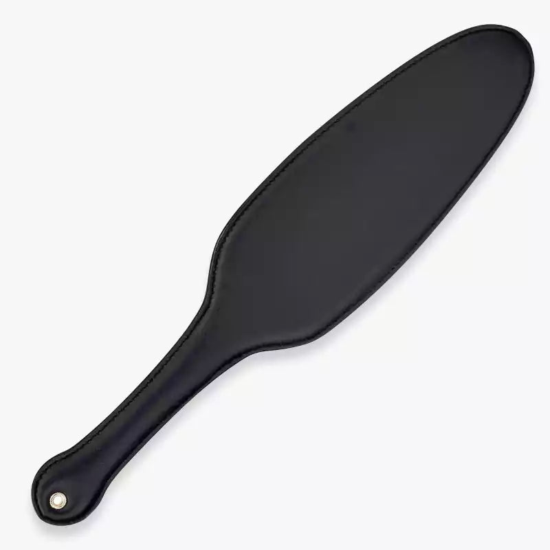 Black oval leather spanking paddle full view under neutral lighting