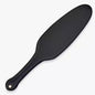 Black oval leather spanking paddle full view under neutral lighting