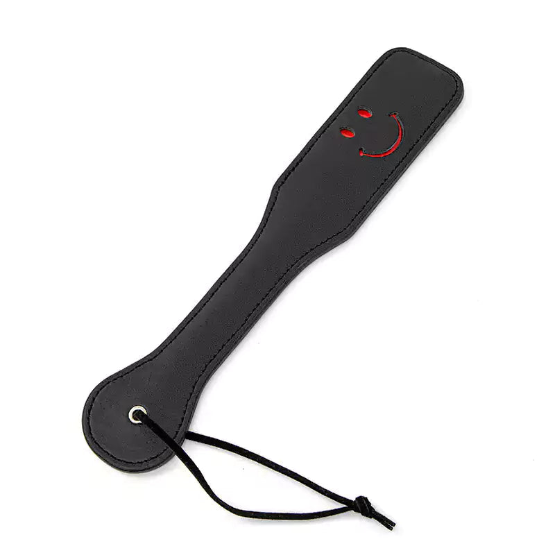 Black smiley leather spanking paddle full view under studio lighting