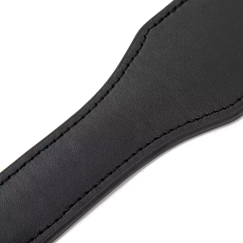 Faux leather spanking paddle handle detail showing grip texture