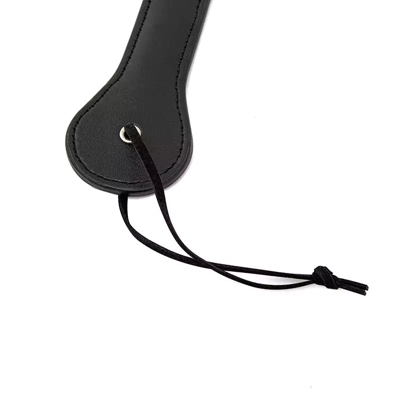Wrist strap detail on black smiley spanking paddle