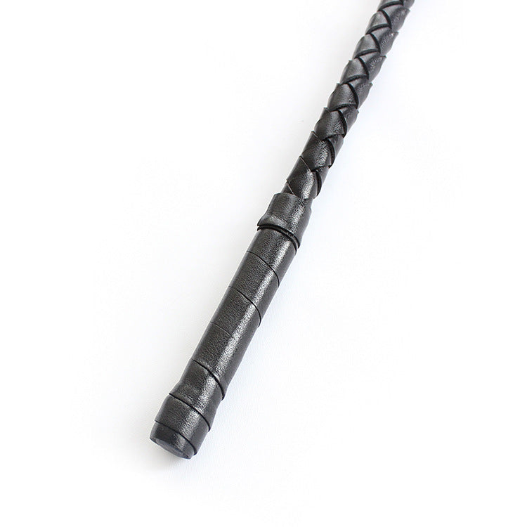 Close-up of braided leather striking tip on BDSM riding crop