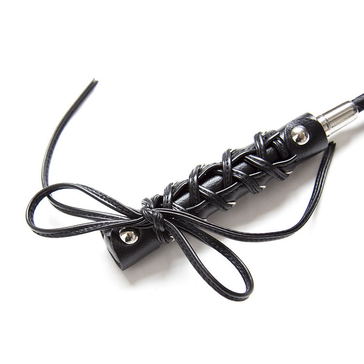 Second close-up of butterfly strap handle detail on BDSM riding crop