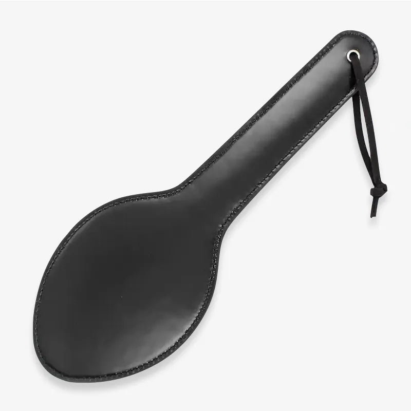 Classic black leather spanking paddle full view under neutral lighting