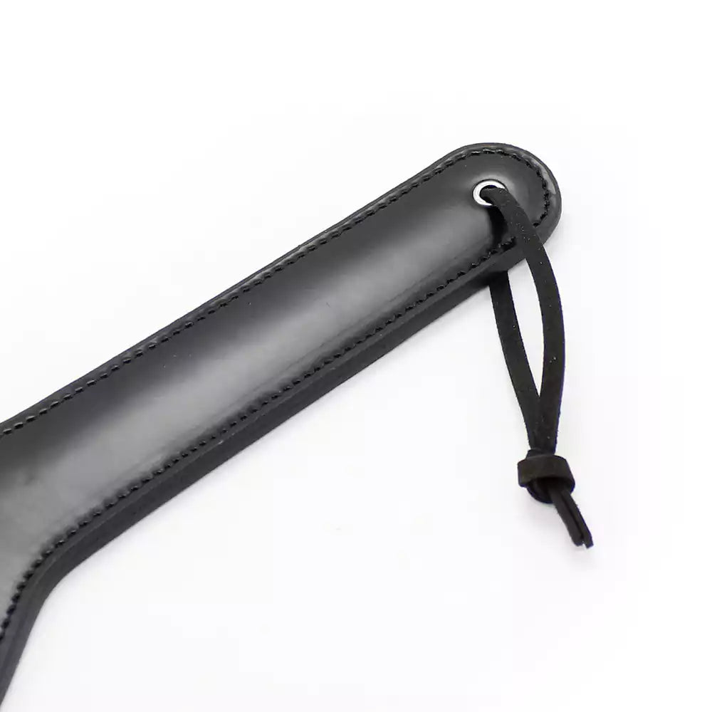 Handle detail of classic black faux leather spanking paddle