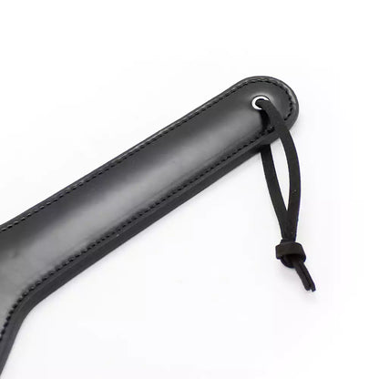 Handle detail of classic black faux leather spanking paddle