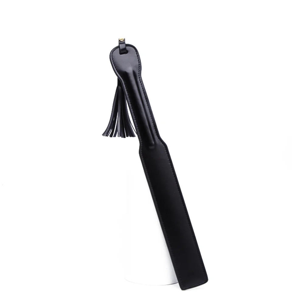 Black leather spanking paddle with tassel on white background