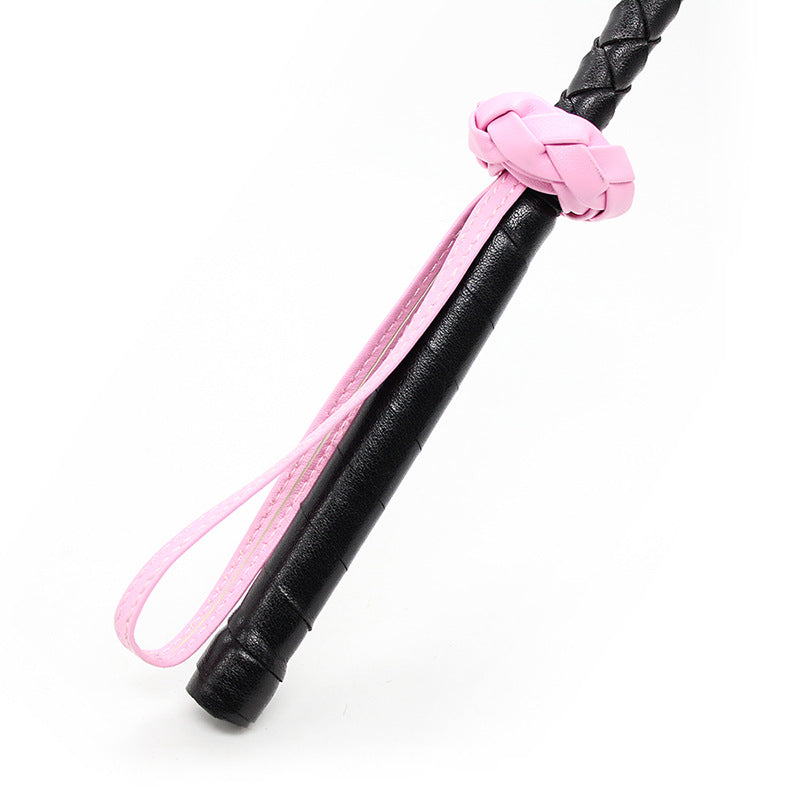 Close-up of braided anti-slip handle on clover leather BDSM riding crop