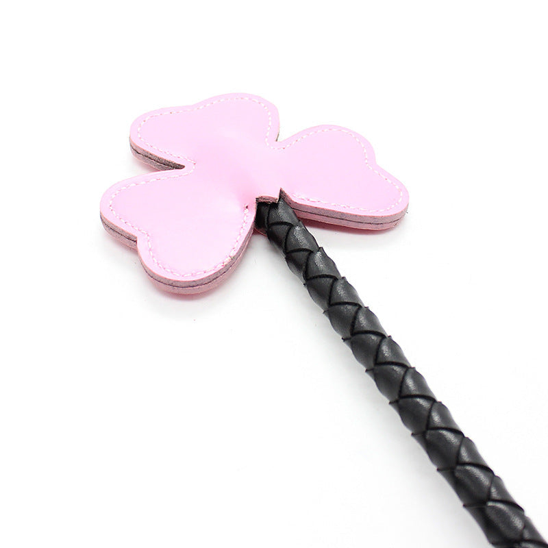 Close-up of clover-shaped faux leather tip on braided riding crop