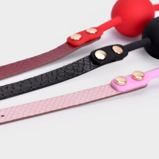 Strap detail comparison of black, black-red and pink ball gags