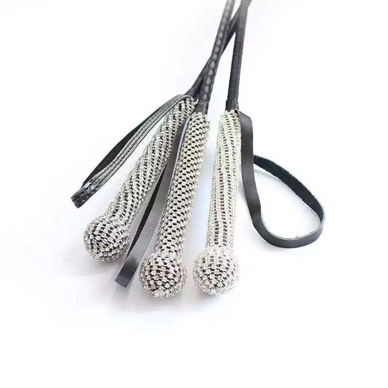 Diamond-handle leather riding crop held showing crystal grip in use