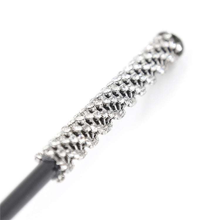 Close-up of crystal diamond-accented handle on riding crop paddle