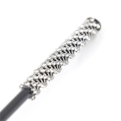 Close-up of crystal diamond-accented handle on riding crop paddle