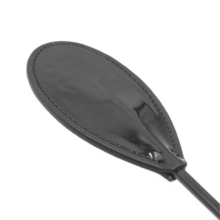 Close-up of glossy faux leather oval head on diamond handle crop paddle