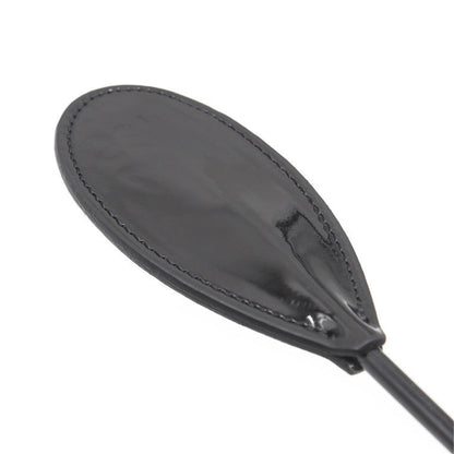Close-up of glossy faux leather oval head on diamond handle crop paddle