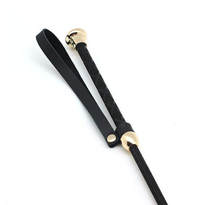 Close-up of cowhide leather handle with gold hardware on feather riding crop
