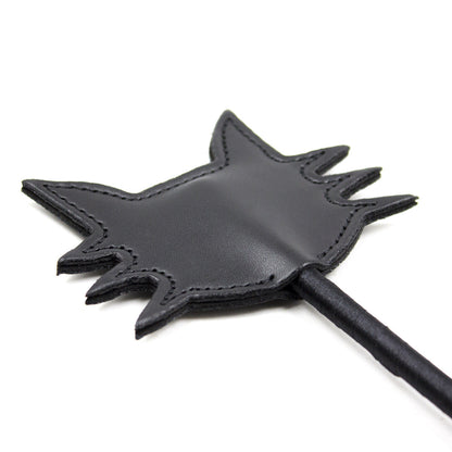 Angled close-up of the black cat face paddle head on the feline silhouette riding crop