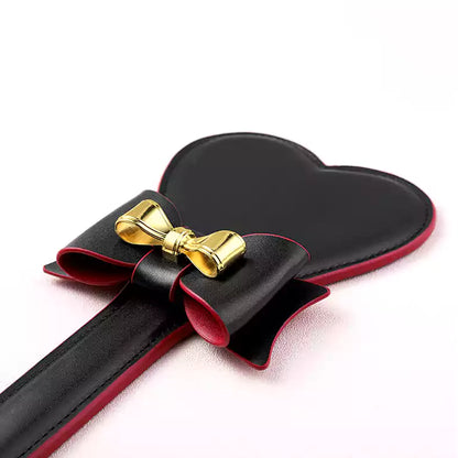 Pala para nalgadas de cuero con lazo y corazón — Diseño de cara de corazón y lazo