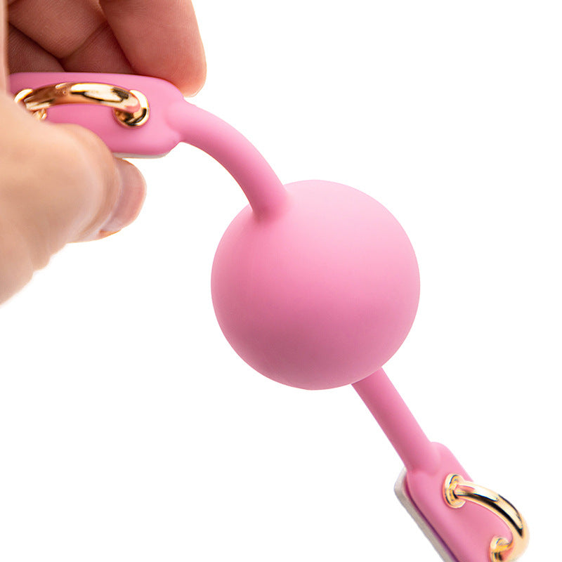 Close-up detail of the pink latex ball on the iridescent bondage ball gag