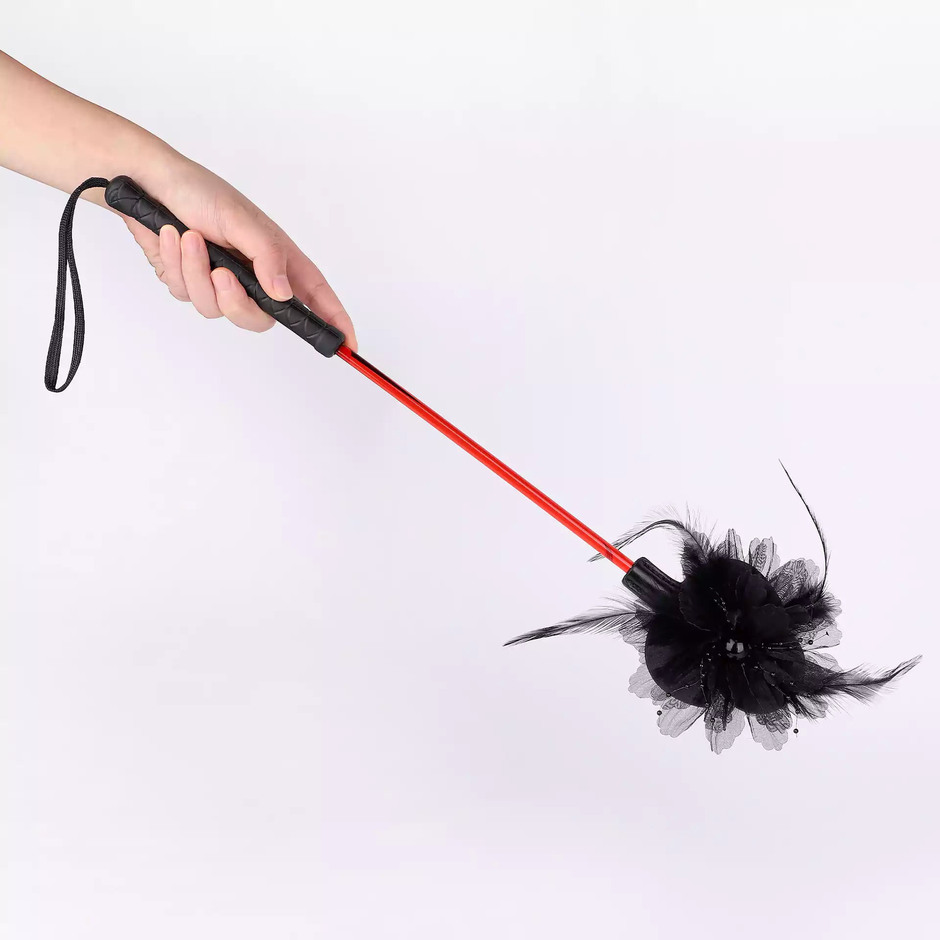 Lace flower riding crop held in hand showing size and grip