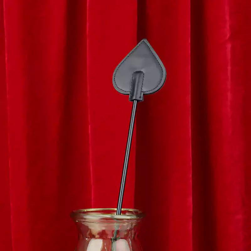 Close-up detail of long-handle riding crop heads on red background
