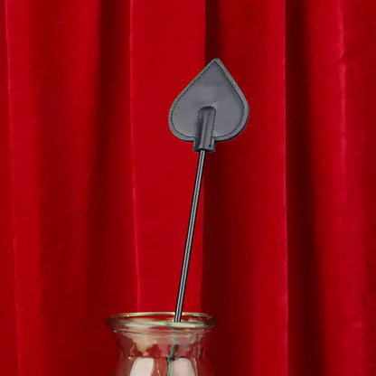 Close-up detail of long-handle riding crop heads on red background