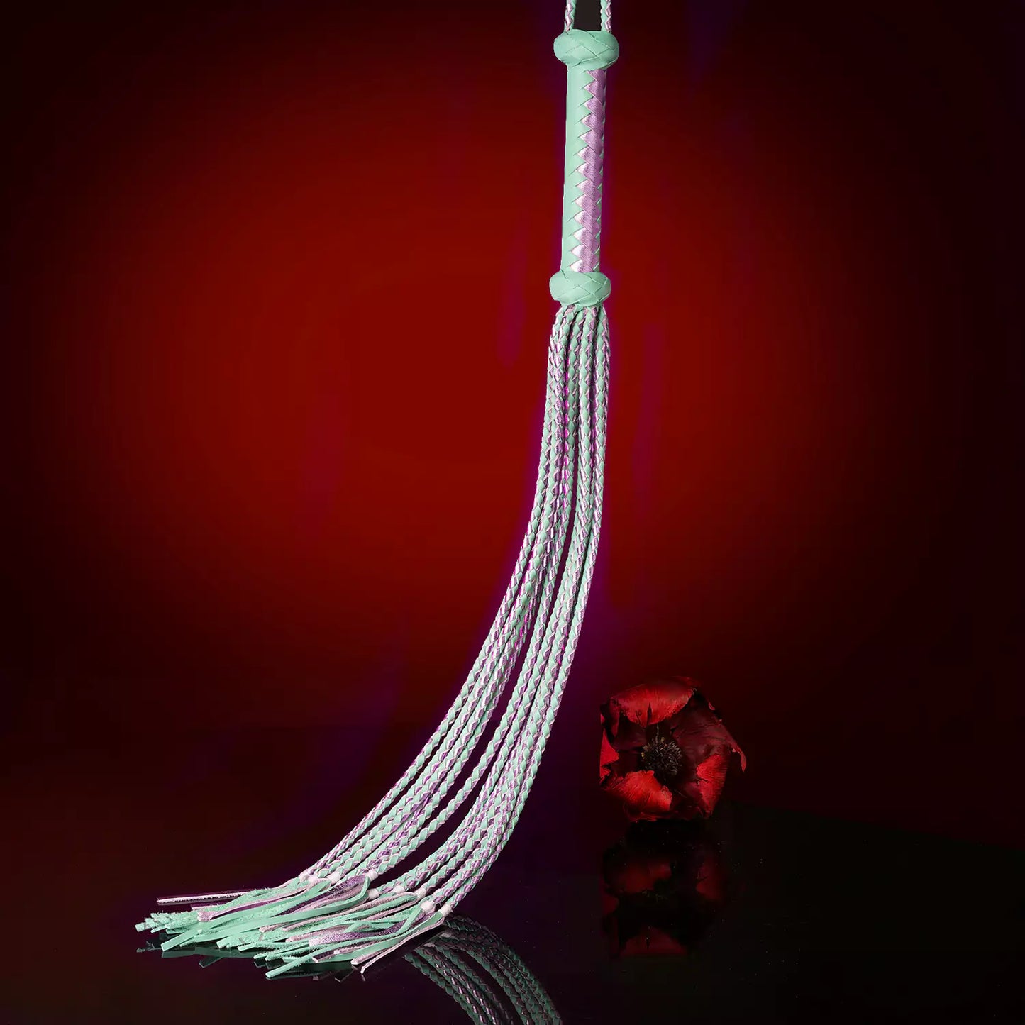 mid-range swing of pastel nine-tail flogger demonstrating layered rhythmic contact