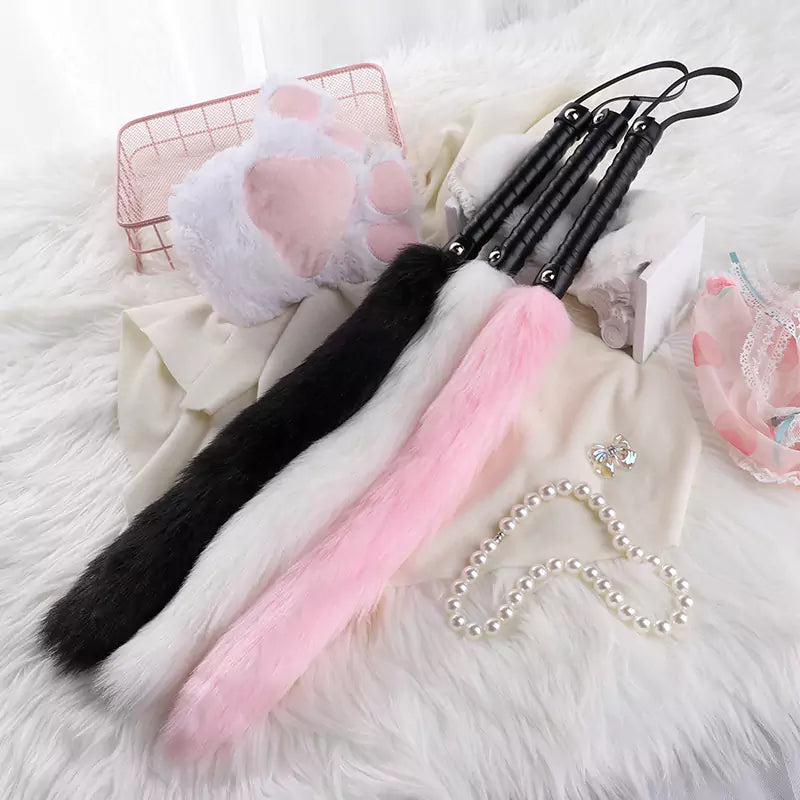 Pink red and white fox tail floggers grouped together