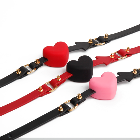 Pink red and black heart arrow silicone ball gags grouped together