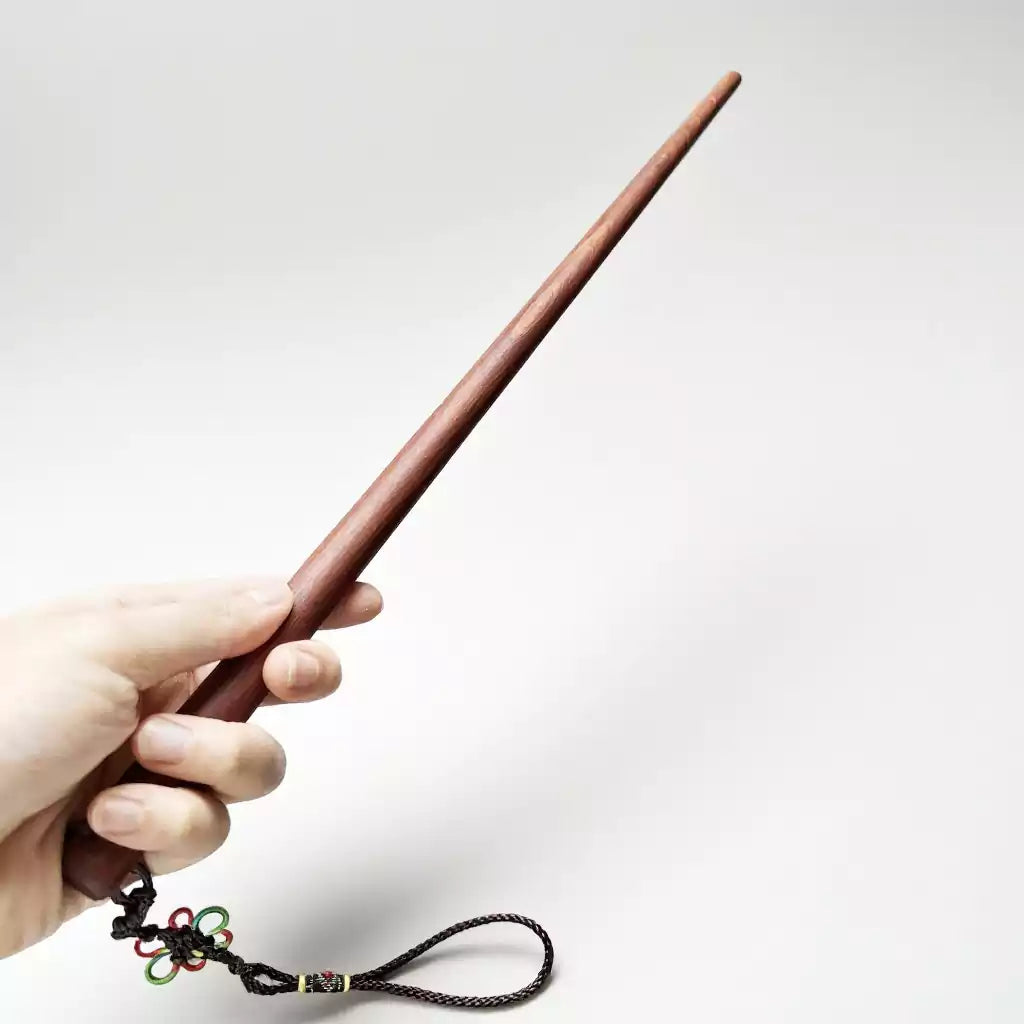 Padauk hardwood teaching cane held in hand showing grip and length