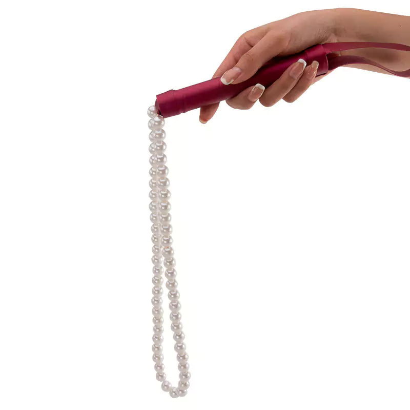 Red leather pearl whip styled in dark setting