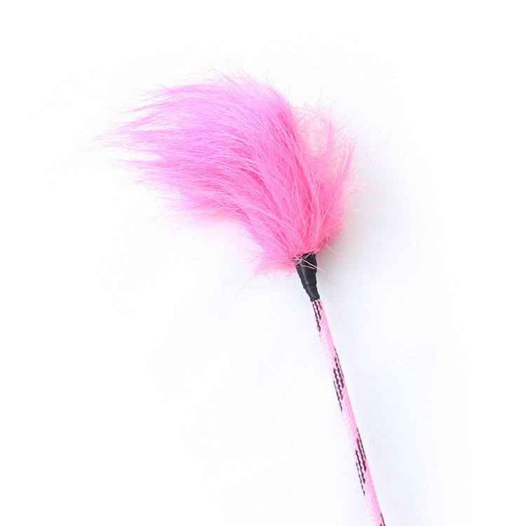 Close-up of fluffy pink feather tip on long sensory riding crop
